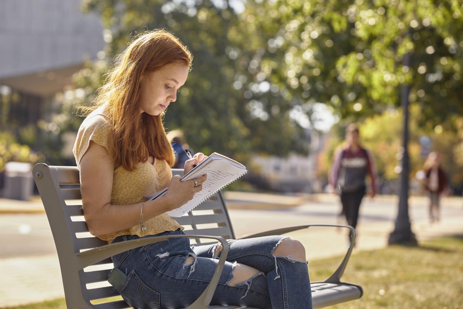 一位<a href='http://odzo.ngskmc-eis.net'>全球十大赌钱排行app</a>学院的学生在校园里的长椅上读书.